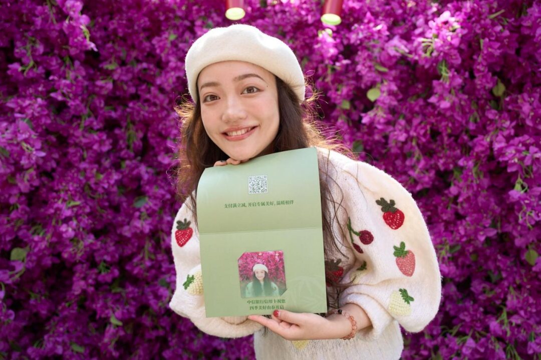 Event photography of a guest holding branded collateral at a Shenzhen brand activation